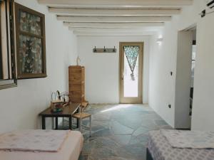 普拉提伊亚洛斯西弗诺斯Melia Sifnos House的客房设有两张床、一张桌子和一扇窗户。