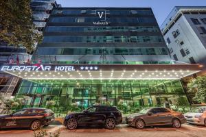 地拉那VH Eurostar Tirana Hotel Congress & Tirana Spa的门前有车辆停放的酒店