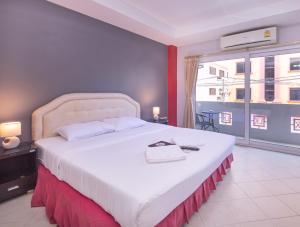 芭堤雅市中心罗宾雀巢旅馆及餐厅的卧室设有一张白色大床和大窗户