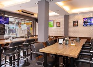 芭堤雅市中心罗宾雀巢旅馆及餐厅的一间带木桌和黑色椅子的餐厅