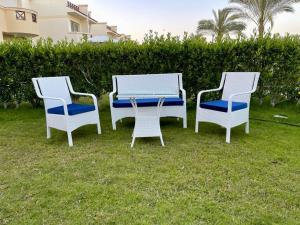 阿莱曼Stella Heights villa - next to Marassi - North coast的草上三把椅子和一张桌子