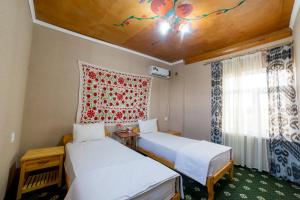 希瓦Islam Khodja的客房设有两张床和窗户。