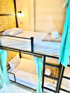 考索Khao Sok Inn Hostel的配有蓝色窗帘的客房内的两张双层床