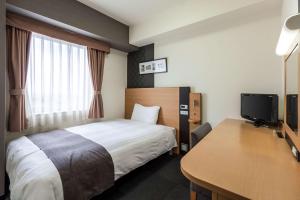 天童市天童康福特茵酒店的配有一张床和一张书桌的酒店客房