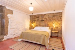 瓜尔达Quinta do Rio Noémi的卧室配有一张石墙床