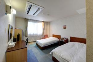 Tsuru ホテルスターらんど的酒店客房设有两张床和电视。