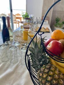 特罗吉尔Hotel Buenavista Beach House Trogir的一张桌子,上面放着一碗水果和 ⁇ 萝