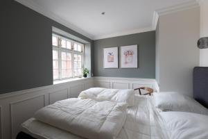 斯卡恩Ankerhus Skagen的卧室配有白色的床和窗户。