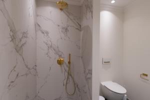 斯卡恩Ankerhus Skagen的白色的浴室设有卫生间和淋浴。