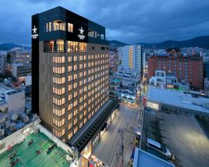 长崎Candeo Hotels Nagasaki Shinchi Chinatown的一座高大的建筑,在城市里设有游泳池