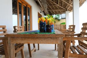 布韦朱Mkunguni Villas的一张木桌,上面有花花瓶