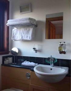 阿勒浦Island View House的浴室配有盥洗盆、镜子和毛巾