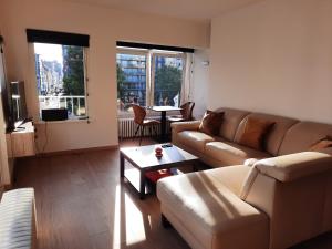 奥斯坦德Lichtrijk en comfortabel hoekappartement met gratis parking en zeer centraal gelegen - Comme Chez Soi的客厅配有沙发和桌子