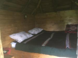 新瓦罗什Ambar的木制客房的一张床位,配有两个枕头