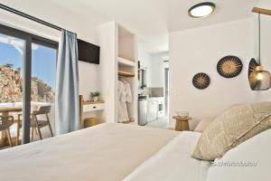 卡尔帕索斯Agnantema luxury suites的一间白色卧室,配有床和厨房