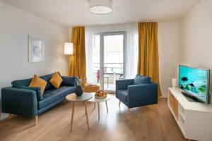 鲁昂DOMITYS Les Mosaïques的客厅配有蓝色的沙发和两把椅子