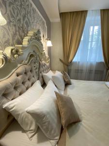 基辅Grand Christer Hotel的卧室配有带枕头的大型白色床