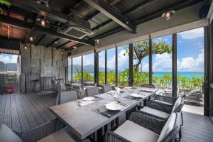 岘港M SUITE Danang Beach的一间带长桌和椅子的用餐室