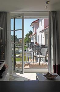 巴贝Haus Meeresblick - Ferienwohnung Windlicht A 2.08 (Ref. 128696)的一间设有滑动玻璃门并通向阳台的客房