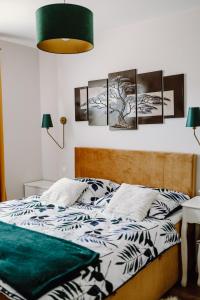 亚沃尔基Pieninski relaks的卧室配有一张壁挂着四幅画作的床