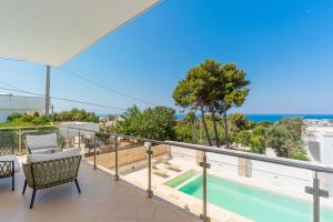 莱乌卡Villa Finibus Terrae的从带游泳池的房屋阳台欣赏风景