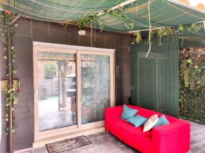 罗马Tiny Green apartament in Rome - Magliana的坐在房子前面的红色沙发