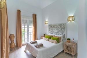 阿德耶Villa Namaste的白色卧室配有一张带绿色枕头的大床