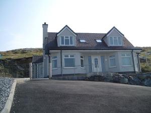 EriskayEriskay Views Cottage的前面有栅栏的白色房子