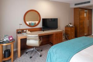 伦敦皇冠假日伦敦多克兰酒店的一间卧室配有一张桌子、一台电视和一张床