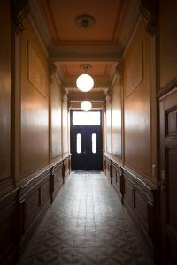 莱比锡科孔公寓酒店的一条空的走廊,有黑色的门和窗户