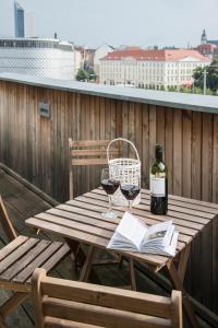 莱比锡科孔公寓酒店的一张木桌,上面放着两杯葡萄酒和一本书