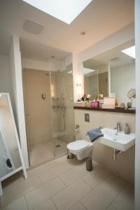 莱比锡科孔公寓酒店的带淋浴、盥洗盆和镜子的浴室