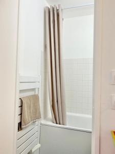 圣马丹德雷Appartement élégant avec vue sur le port的白色的浴室设有浴缸和淋浴帘
