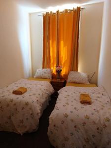 Hebburn-on-TyneThe Cosy 2 bedroom flat, sleeps 6的带两张床和橙色窗帘的房间