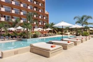马尔格莱特德玛Luna Park Hotel Yoga & Spa的酒店游泳池设有躺椅和遮阳伞