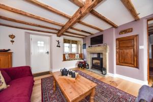 奥尔弗里顿Old Horns Cottage, Higham Derbyshire的客厅设有红色的沙发和壁炉