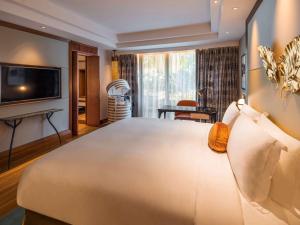 新加坡Sofitel Singapore Sentosa Resort & Spa的一间带大床的卧室和一间客厅