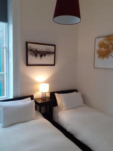 爱丁堡St James Quarter 2 Bed Apartment的一张桌子上灯的房间里两张床铺