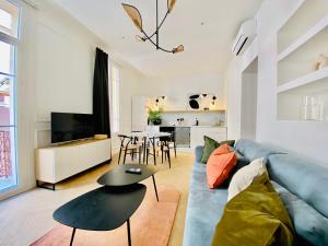 蒙特卡罗Newly Renovated Apartment with Balcony, AC, Fiber internet的客厅配有蓝色的沙发和桌子