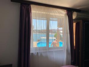 索佐波尔Villas Sozopol的一间卧室设有享有泳池景致的窗户