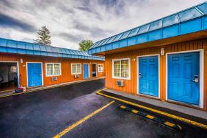 本德Royal Gateway Motel by OYO的停车场内一排带蓝色门的建筑