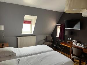 斯特拉斯堡奥瑟夫多尔餐厅酒店的酒店客房设有两张床、一张书桌和一个窗户。