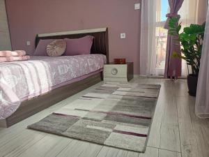 鲁塞Стоянови的卧室配有一张铺在地板上的地毯。