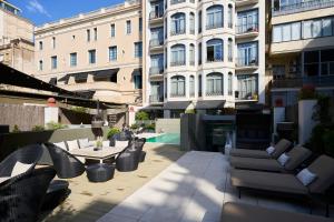巴塞罗那加泰罗尼亚格拉西亚大道酒店的一座带桌椅的庭院和一座建筑