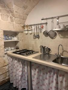 奥斯图尼Casa Angelica的厨房配有水槽和炉灶 顶部烤箱