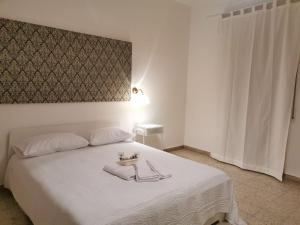 雷焦卡拉布里亚Al Cortile的卧室配有白色的床和床头板
