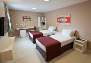 伊塔瓜伊格兰德伊塔瓜伊酒店的酒店客房设有两张床和电视。