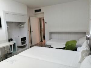 马德里马德里普拉多宜必思尚品酒店的白色卧室,配有床和绿色椅子