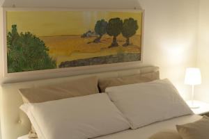 阿尔贝罗贝洛BORGANTHIA的白色沙发上方的画作,带两个枕头