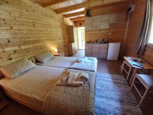 DobrilovinaVila Montana的木制客房内的一间卧室配有两张床
